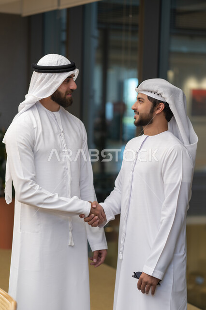 رجلا اعمال عربيان إماراتيان خليجيان يتصافحان، الإتفاق والشراكة على الأعمال والمشاريع التجارية، شركاء عمل، صفقة عمل جديده, التعاون بين الشركات، بيئة عمل إماراتيه، إتفاقية عمل, شركات عربيه إماراتيه خليجيه في الإمارات العربيه المتحده