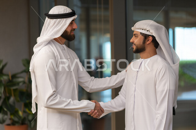 رجلا اعمال عربيان إماراتيان خليجيان يتصافحان، الإتفاق والشراكة على الأعمال والمشاريع التجارية، شركاء عمل، صفقة عمل جديده, التعاون بين الشركات، بيئة عمل إماراتيه، إتفاقية عمل, شركات عربيه إماراتيه خليجيه في الإمارات العربيه المتحده