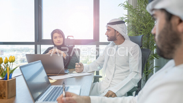Arab Gulf Emirati team in a business meeting, meeting room, businessmen, business discussions and dialogues, work follow-up, Emirati work environment, work team, office work, study and review of projects, supervision and audit work, work session
