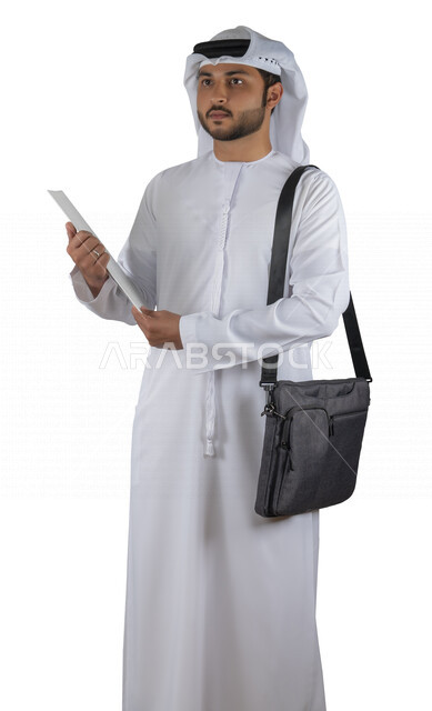 بورتريه طالب جامعي عربي خليجي اماراتي يضع الحقيبة على ظهرة ، يحمل بيده كتاب جامعي، قراءة الكتب الجامعية، مراجعة الدروس اليومية، التعليم الجامعي في الإمارات العربية المتحدة ، خلفية بيضاء .