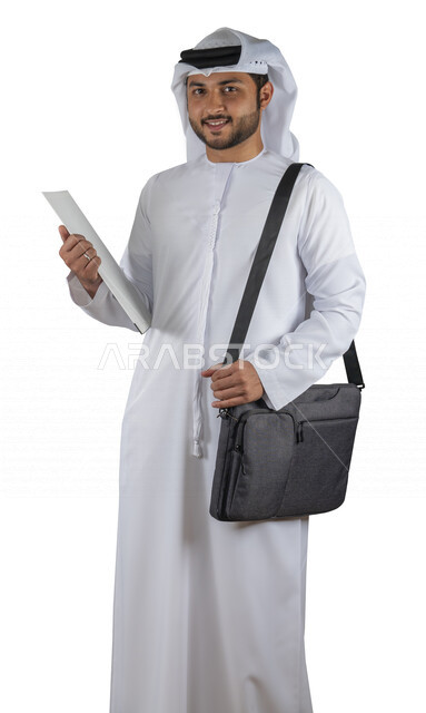 بورتريه طالب جامعي عربي خليجي اماراتي يضع الحقيبة على ظهرة ، يحمل بيده كتاب جامعي، قراءة الكتب الجامعية، مراجعة الدروس اليومية، التعليم الجامعي في الإمارات العربية المتحدة ، خلفية بيضاء .