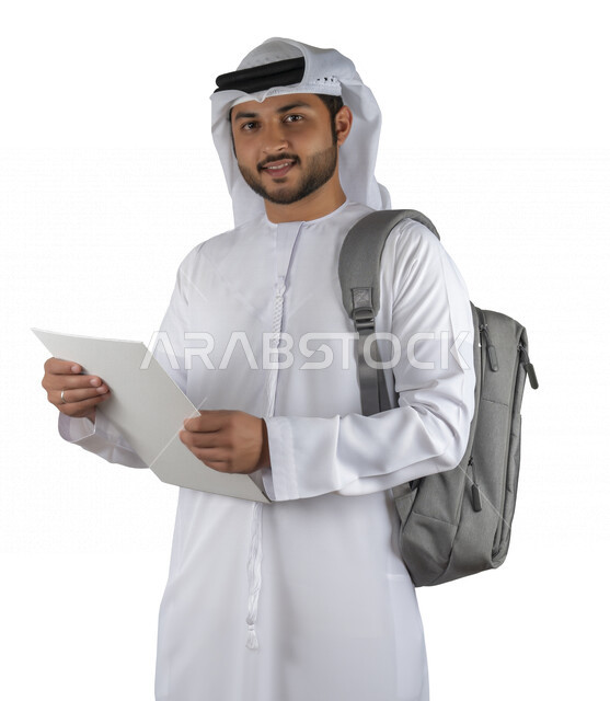 بورتريه طالب جامعي عربي خليجي اماراتي يضع الحقيبة على ظهرة ، يحمل بيده كتاب جامعي، قراءة الكتب الجامعية، مراجعة الدروس اليومية، التعليم الجامعي في الإمارات العربية المتحدة ، خلفية بيضاء .