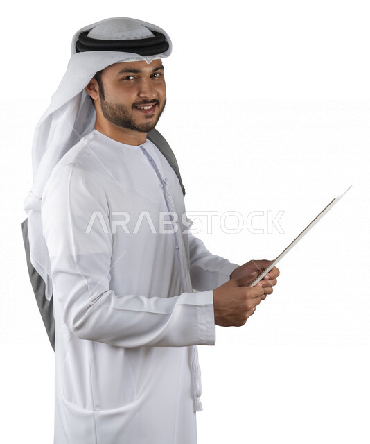 بورتريه طالب جامعي عربي خليجي اماراتي يضع الحقيبة على ظهرة ، يحمل بيده كتاب جامعي، قراءة الكتب الجامعية، مراجعة الدروس اليومية، التعليم الجامعي في الإمارات العربية المتحدة ، خلفية بيضاء .