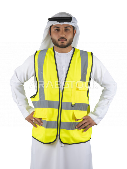 بورتريه مهندس عربي خليجي اماراتي يرتدي سترة حماية خاصة بالعمل ، مهن و وظائف هندسية ، ادارة المشاريع الهندسية، مفهوم الهندسة ، مهندس معماري محترف ، مخططات و تصماميم هندسية، تدقيق العمل , خلفية بيضاء .