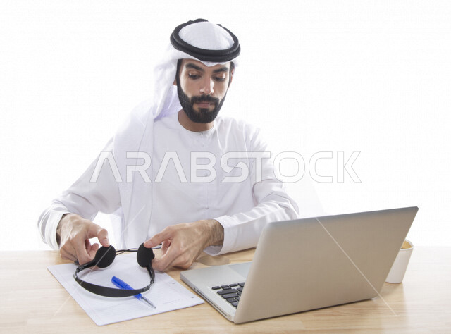 بورتريه موظف عربي خليجي اماراتي يعمل في خدمة العملاء ويرتدي سماعة الاتصال، استعلامات واستفسارات، الاجابه على اسئلة العملاء، اجراء اتصال فيديو من خلال الحاسوب ، متابعة وتطوير العمل , خلفية بيضاء .