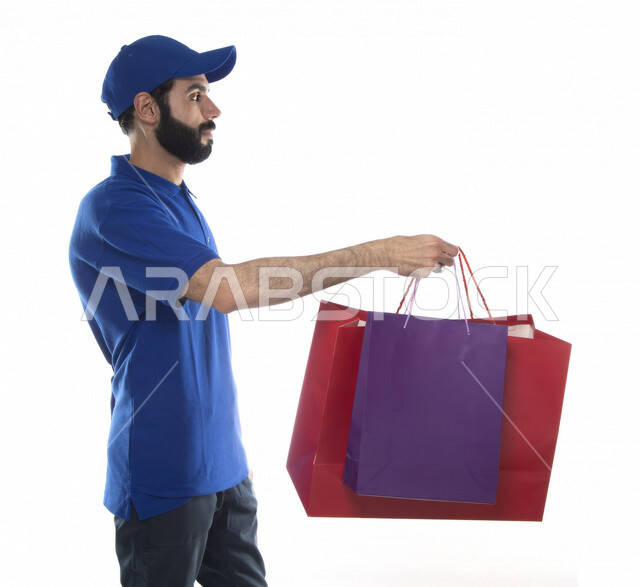 بورتريه رجل عربي اماراتي خليجي يعمل في توصيل طلبات التسوق للزبائن, التسوق الالكتروني, طلبات اونلاين, التسوق الذكي, عملية شحن وتوصيل موثوقه, مندوب توصيل البضائع , امين مخازن , خلفية بيضاء . 