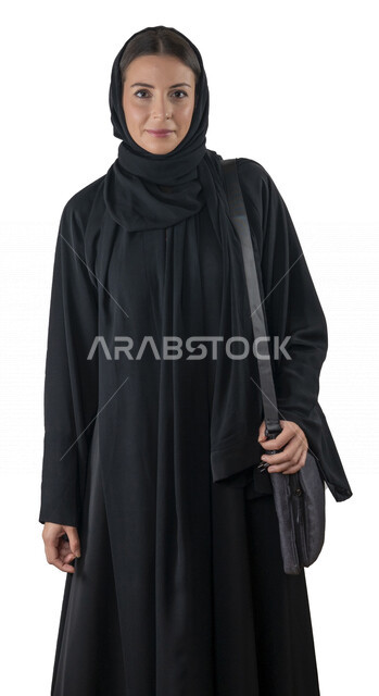 بورتريه لطالبة جامعية عربية إماراتيه خليجية محجبة مبتسمه تحمل حقيبة اللابتوب على كتفها, تنظر الى الكاميرا, موظفه في شركه إماراتيه, شابة متشوقة للذهاب الى العمل, خلفية بيضاء