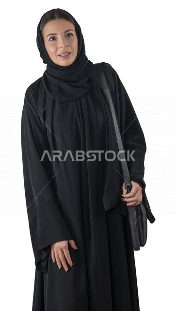 بورتريه لطالبة جامعية عربية إماراتيه خليجية محجبة مبتسمه تحمل حقيبة اللابتوب على كتفها, تنظر الى الكاميرا, موظفه في شركه إماراتيه, شابة متشوقة للذهاب الى العمل, خلفية بيضاء