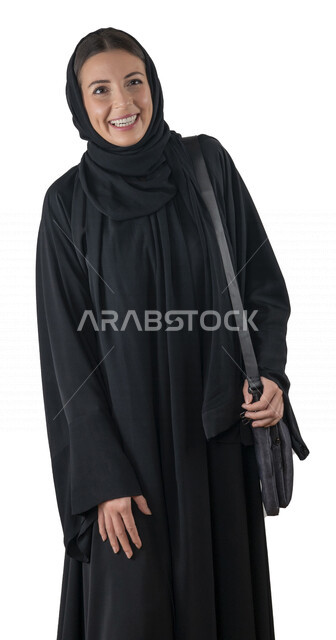 بورتريه لطالبة جامعية عربية إماراتيه خليجية محجبة مبتسمه تحمل حقيبة اللابتوب على كتفها, تنظر الى الكاميرا, موظفه في شركه إماراتيه, شابة متشوقة للذهاب الى العمل, خلفية بيضاء