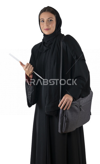 بورتريه لطالبة جامعية عربية إماراتيه خليجية محجبة مبتسمه تحمل حقيبة اللابتوب على كتفها, تمسك بيدها أوراق عمل, تنظر الى الكاميرا, موظفه في شركه إماراتيه, شابة متشوقة للذهاب الى العمل, خلفية بيضاء
