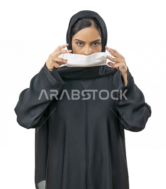بورتريه لشابة عربية خليجية اماراتية تقوم بارتداء الكمامة لتجنب تفشي الفايروس ، اتباع اجراءات الحماية والسلامة ، تجنب انتشار العدوى ، كورونا , خلفية بيضاء