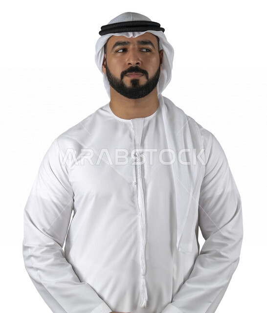 بورتريه لرجل عربي إماراتي خليجي يرتدي الزي الإماراتي التقليدي يقف بإستقامه, ينظر إلى شيء ما, الإهتمام بالمظهر الخارجي, إيماءات وجه ويدين مختلفة، خلفية بيضاء