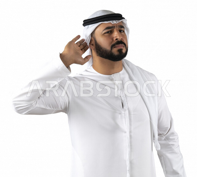 بورتريه لرجل عربي إماراتي خليجي يضع يده خلف أذنه ، بايماءات تدل على الانصات ، التركيز في الكلام ، ضعف السمع ، التنصت والتجسس ،الاستماع الى الاسرار والمحادثات, خلفيه بيضاء 