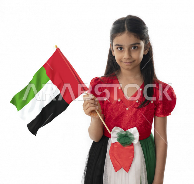 خلفية بيضاء, الإحتفال بيوم الاستقلال لدولة الإمارات العربية المتحدة, بورتريه مقرب لبنت عربية خليجية إماراتية ترتدي فستان بألوان علم الإمارات, هوية اليوم الوطني الإماراتي51, فتاة تحمل بيدها علم الامارات وتنظر الى الكاميرا, تقديم الولاء والحب للوطن