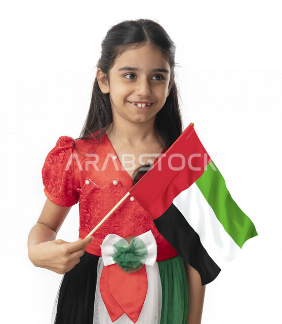 الإبتسامة أمام الكاميرا, فتاة تحمل بيدها علم الإمارات, الإحتفال بيوم الاستقلال لدولة الإمارات العربية المتحدة, بورتريه مقرب لبنت عربية خليجية إماراتية ترتدي فستان بألوان علم الإمارات, هوية اليوم الوطني الإماراتي51, تقديم الولاء والحب للوطن, خلفية بيضاء