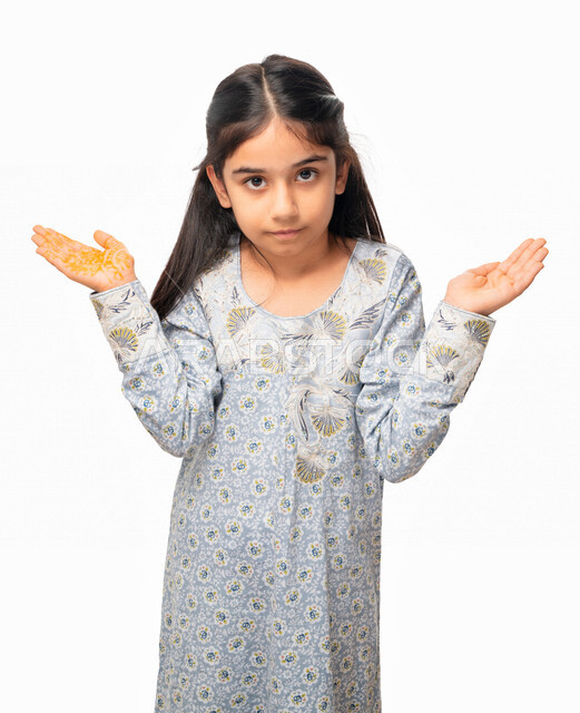  الحيرة و التفكير، قضاء اوقات ممتعه في العطلة، بورتريه مقرب لفتاة عربية امارتية تقوم بحمل عناصر هولوجرامية، تقنية الهولوجرام ثلاثية الابعاد, ايماءات يدين ووجه تدل على السعادة, بنت سعودية ترتدي الثوب الخليجي تقوم بممارسة الالعاب الحركية، خلفية بيضاء