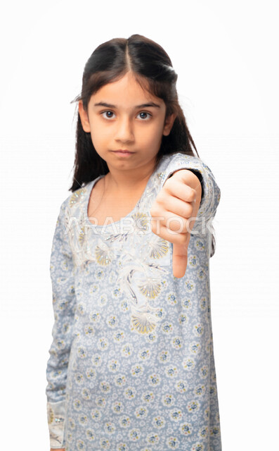 الفشل والخسارة ، الرفض و عدم القبول, بورتريه مقرب لفتاة عربية اماراتية خليجية تشير بأصبع الابهام الى الاسفل ، حركات يد تدل على عدم الموافقه و عدم الإعجاب, بنت سعودية ترتدي الثوب الخليجي وتشعر بالإنزعاج من شيء ما، خلفية بيضاء