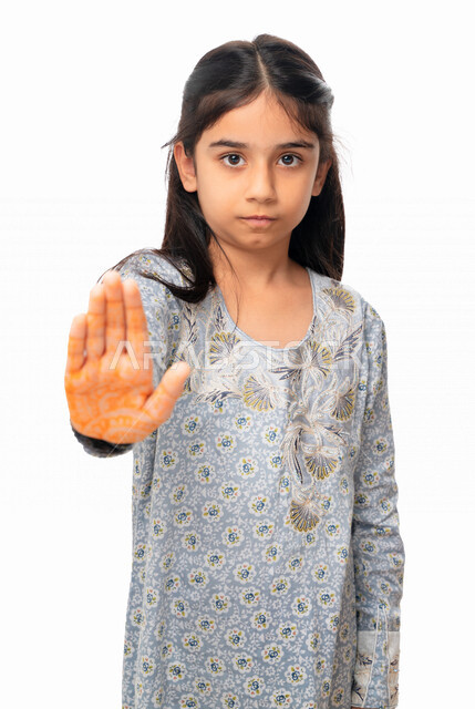 Two hands gestures indicating the command to stop doing something and forbidding it, a Saudi girl wearing the Gulf dress and feeling annoyed, rejected and refraining, silence and stopping talking, a portrait of an Arab Emirati Gulf girl raising her palm u