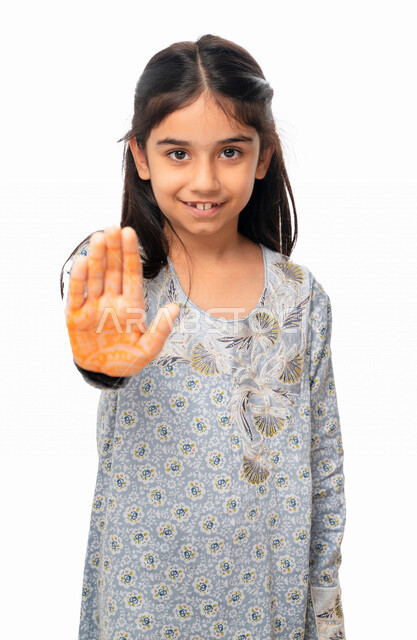 Two hands gestures indicating the command to stop doing something and forbidding it, a Saudi girl wearing the Gulf dress and feeling annoyed, rejected and refraining, silence and stopping talking, a portrait of an Arab Emirati Gulf girl raising her palm u