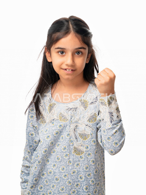 الشعور بالسعاده و الرضا و الإعجاب، بورتريه مقرب لفتاة سعودية ترتدي الثوب الخليجي بايماءات وجه ويدين تدل على الفوز والإنتصار, تحقيق الاهداف و إنجاز المهامات , بنت اماراتية عربية خليجية تشير بعلامة الكسب والقوه, خلفية بيضاء