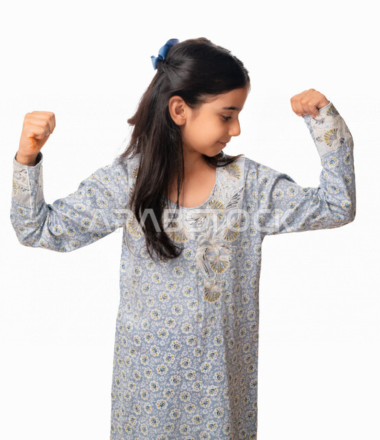  الصحه الجسديه و ممارسة الرياضه للحفاظ على الجسم السليم, بورتريه مقرب لفتاة عربية اماراتية خليجية بإشارات وجه ويدين تدل على القوه, بنت سعودية ترتدي الثوب الخليجي تقوف بفعل حركة العضلات ذات الرأسين, اللياقه البدنيه، خلفية بيضاء