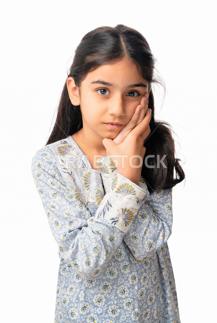 التفكير بشيء ما، تسوس الأضراس و إلتهاب اللثه, بورتريه مقرب لفتاه عربية اماراتيه خليجية تضع يدها على خدها ،إيماءات وجه ويدين تدل على الشعور بألم الأسنان, بنت سعودية ترتدي الثوب الخليجي بحاجه لزيارة طبيب الأسنان لوضع خطة علاجية، خلفية بيضاء