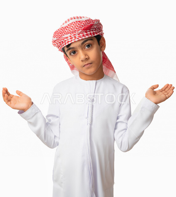 إيماءات و تعابير تدل على الحيرة و الدهشة ،بورتريه لولد عربي اماراتي سعودي يرتدي الكندورة والعمامة الاماراتية  يرفع يديه عاليا بإستغراب ،التفكير و التساؤل، خلفية بيضاء