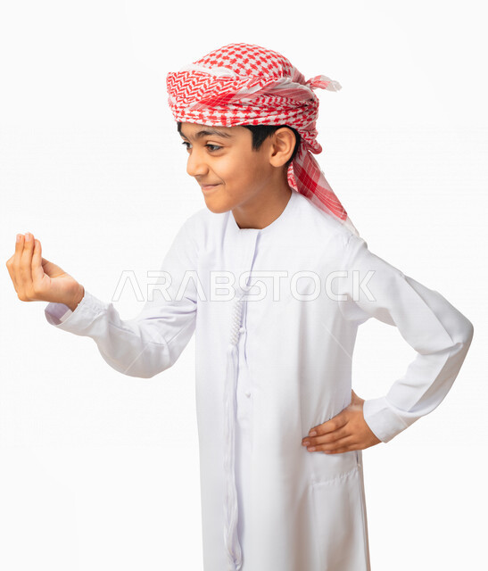 Giving some time to do something, threatening and promising something, a portrait of an Emirati Arab Gulf child wearing a kandora and an Emirati turban and placing his hand on his waist, hand gestures indicating a request to wait, patience, patience, and 