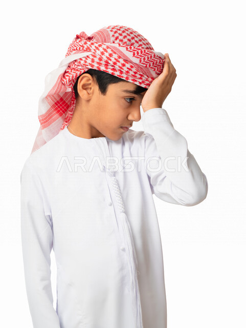 الندم على شيء ما و الرغبة بالبكاء, الاحساس بألم في الرأس, بورتريه لولد عربي اماراتي خليجي يرتدي الكندورة والعمامة الاماراتية, حركات وجه ويدين تدل على الشعور بالخيبه و الحزن والإحباط, الخساره والفشل، الحسرة والخذلان,  خلفية بيضاء 