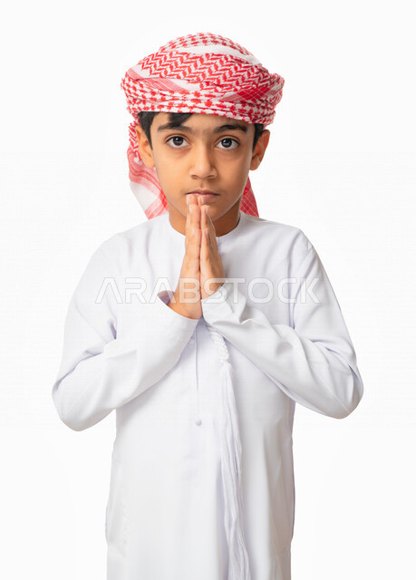 إيماءات وجه ويدين تدل على الدعاء والتضرع الى الله, بورتريه مقرب لولد عربي اماراتي خليجي يرتدي الكندورة والعمامة الاماراتية , الحمد والشكر و طلب العون, الرغبه في تحقيق الأمنيات, طلب المغفره من الله تعالى، خلفية بيضاء