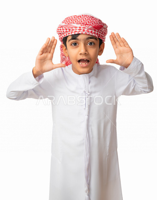 قضاء أوقات ممتعه في وقت الفراغ, بورتريه مقرب لولد عربي اماراتي خليجي يرتدي العمامة والكندورة الاماراتية , ايماءات يدين ووجه تدل على المفاجأة و اللعب , التسلية والترفيه , خلفية بيضاء