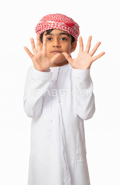 حركات يدين لإبعاد وإيقاف وصد الاذى، بورتريه لولد عربي اماراتي خليجي يرتدي الكندورة والعمامة الاماراتية ويقوم برفع يديه خوفا من شيء ما, ايماءات الخوف و أخذ الحيطة والحذر ، الدفاع عن النفس, خلفية بيضاء