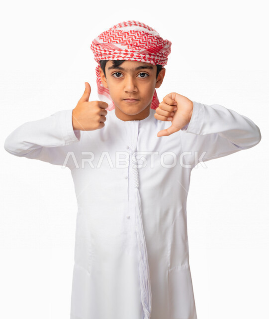 ايماءات يد تدل على عدم التردد في شيء ما, بورتريه لولد عربي اماراتي خليجي يرتدي الكندورة والعمامة الاماراتيه, عدم الإعجاب والإعجاب و الرفض و القبول, رفع أصبع الإبهام لأعلى وأسفل, الموافقة وعدم الموافقة ، خلفية بيضاء