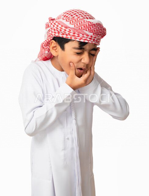 التهاب اللثه وتسوس الأَضراس, الاحتياج الى زيارة طبيب الأسنان، بورتريه لولد عربي اماراتي خليجي يرتدي الكندورة و العمامة الاماراتية, إيماءات وجه ويدين تدل على الشعور بألم الأسنان, التعب والإرهاق, طلب العلاج و المساعده, خلفية بيضاء