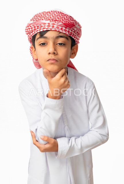 التمعن والتركيز لإيجاد حل لمشكلة، بورتريه مقرب لولد عربي اماراتي خليجي يرتدي الكندورة والعمامة, إيماءات وجه ويدين تدل على التفكير بشيء ما, التأمل والتفكير و التخطيط للمستقبل, خلفية بيضاء