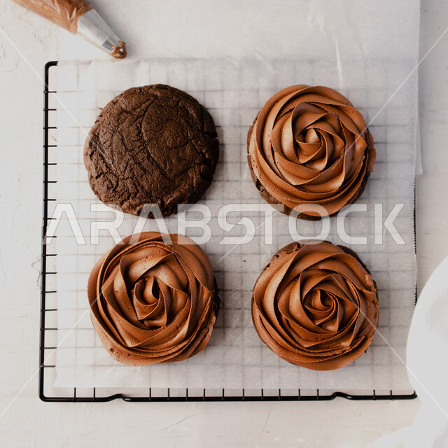 قطع كوكيز الشوكلاتة مزينة بكريمة الشوكولاتة، رقائق الشوكولاته الساخنة، رقاقات البسكويت الهشة والخفيفة مع قطع الشوكولاته الداكنة اللذيذة، بسكويت برقائق الشوكولاتة، حلويات مخبوزة طازجة