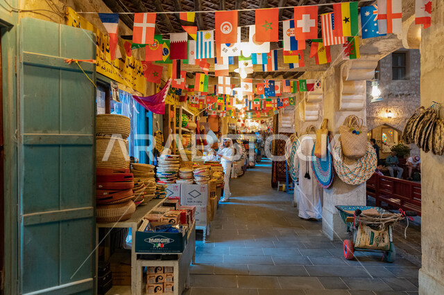 رجل عربي خليجي في احد اسواق الاعمال اليدوية في قطر، منتجات و حرف شعبية في سوق واقف السياحي، اعلام دول العالم المشاركة في مونديال قطر،  كأس العالم في قطر 2022، بطولة كأس العالم، فيفا 2022، السياحة في قطر