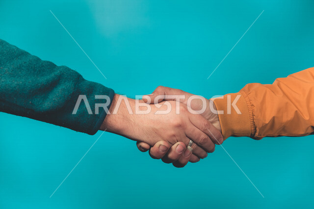 صورة مقربة ليد رجلان يتصافحان، السلام والتحية، التعارف والصداقات، خلفية زرقاء