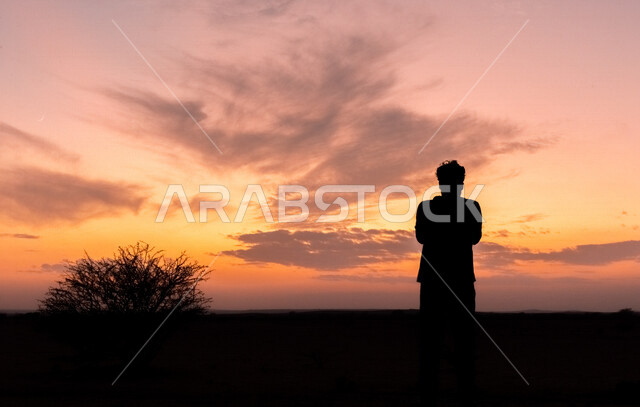 صوره ظليه لرجل يقف في وسط الصحراء, منظر رائع لغروب الشمس على الصحراء, التأمل والاسترخاء, خلفية الطبيعه