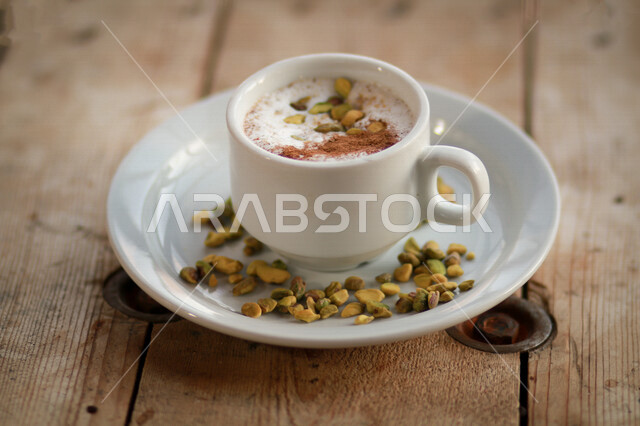 كوب من مشروب السحلب مع القرفة والمكسرات، مشروبات ساخنة، مشروب السخلب اللذيذ، فنجان السحلب الساخن