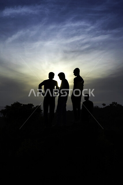 صورة ظلية لمجموعة من الأشخاص في مناطق منعزلة ، جمال منظر الشروق في سماء الزرقاء ، خلفية الطبيعة