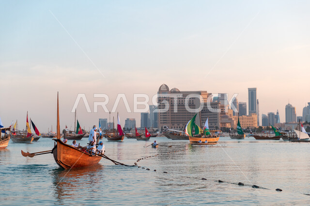 A group of wooden boats on the Doha Corniche in the State of Qatar raising the flags of the countries of the world, flags in the form of a sail, the World Cup in Qatar 2022, the World Cup Championship, FIFA 2022, the World Cup Qatar, tourism in Qatar