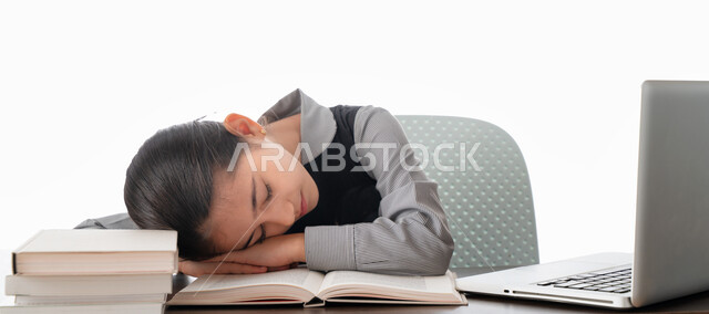 Feeling of laziness and lethargy, sleeping at the study table, gestures of sleepiness, fatigue and exhaustion, a portrait of an Arab Gulf Emirati student wearing a school uniform neglecting her lessons, the disadvantages of distance learning, a Saudi stud