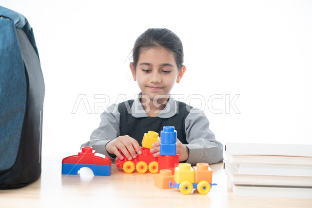 مهارات وآفاق التعليم عن طريق اللعب, تعزيز الابتكارات باستخدام نظام المنتسوري لتنشيط وتحفيز القدرات العقلية  والحركية, بورتريه لطالبه عربية خليجية إماراتية ترتدي الزي المدرسي تجلس في بيئة تعليمية حديثة, تلميذة سعودية في إحدى المدراس الأكاديمية, خلفية بيضاء