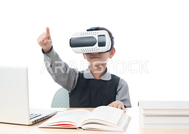 جمع التعلم مع الترفيه باستخدام التكنولوجيا الحديثة، بورتريه لتلميذة عربية خليجية اماراتية ترتدي الزي المدرسي تشير إلى شيء ما وتتفاعل مع العالم الافتراضي التعليمي، طالبة سعودية تجلس على طاولة الدراسة، التعليم الذكي عبر نظارات الواقع الافتراضي، خلفية بيضاء