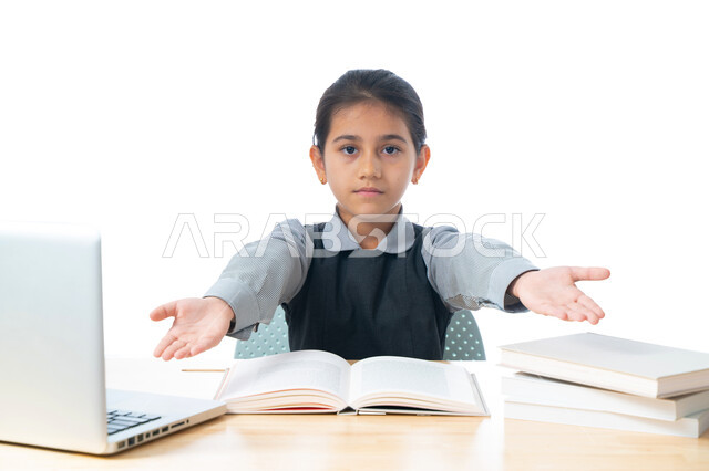 مفهوم التعليم الإلكتروني، بورتريه لطالبة عربية خليجية اماراتية ترتدي اليونيفورم المدرسي، ايماءات وجه ويدين تدل على الضغط والتعب من كمية الوجبات والدروس، تلميذة سعودية تتابع دروسها عن طريق الكمبيوتر، التعلم عن بعد باستخدام التكنولوجيا الحديثة، خلفية بيضاء