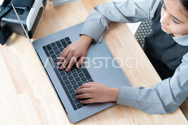 مفهوم المذاكره والمثابره على التقدم والنجاح، بورترية مقرب لتلميذة خليجية عربية إماراتية ترتدي اليونيفورم المدرسي وتتابع حصص الاونلاين عبر الحاسوب، طالبه سعودية مجتهده متفوقه تدرس عن بعد عبر الانترنت، الاستعداد للإمتحانات والاختبارات المدرسيه، خلفية بيضاء