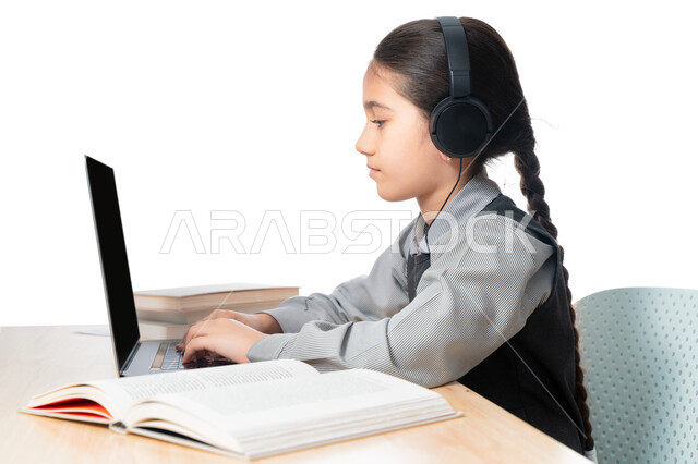  مفهوم التعليم الإلكتروني، بورترية مقرب لتلميذة خليجية عربية إماراتية ترتدي الزي المدرسي و سماعة الرأٍس، حضور البث المباشر للحصص الاونلاين عن طريق الكمبيوتر، طالبة سعودية تذاكر دروسها من الحاسوب، الإستعداد للإمتحانات و الإختبارات النهائية ، خلفية بيضاء