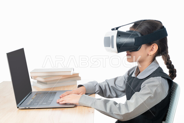 متابعة حصص الاونلاين عن طريق الكمبيوتر، بورترية مقرب لتلميذة خليجية عربية إماراتية ترتدي الزي المدرسي و تدرس في المنزل، مفهوم التعليم الإلكتروني، طالبة سعودية ترتدي نظارات الواقع الإفتراضي وتتفاعل مع البث المباشر، حل الواجبات عبر الانترنت، خلفية بيضاء