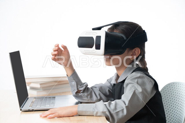 متابعة حصص الاونلاين عن طريق الكمبيوتر، بورترية مقرب لتلميذة خليجية عربية إماراتية ترتدي الزي المدرسي و تدرس في المنزل، مفهوم التعليم الإلكتروني، طالبة سعودية ترتدي نظارات الواقع الإفتراضي وتتفاعل مع البث المباشر، حل الواجبات عبر الانترنت، خلفية بيضاء